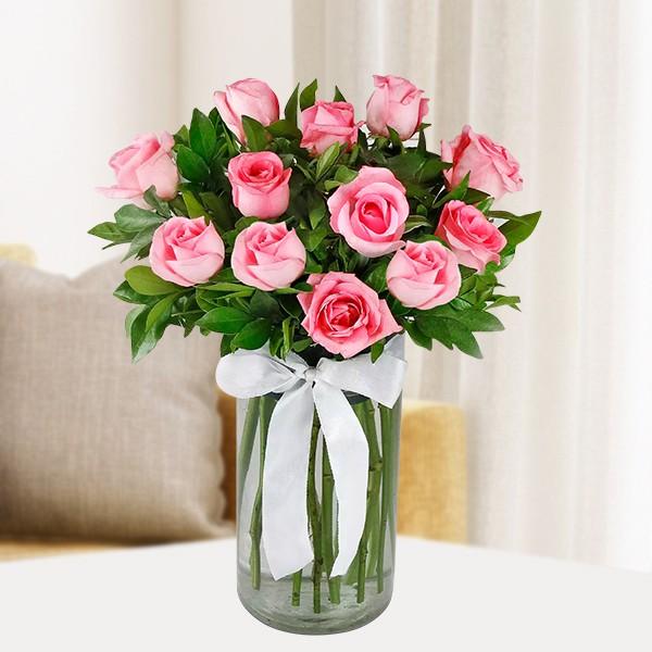 Elegant clear glass vase arrangement featuring fresh pink lilies, red roses, and lush greenery for online delivery in Hyderabad