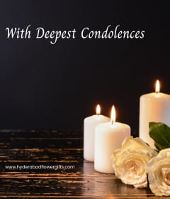 Serene white lily and carnation sympathy floral arrangement with condolence card for delivery in Banjara Hills and Jubilee Hills Hyderabad